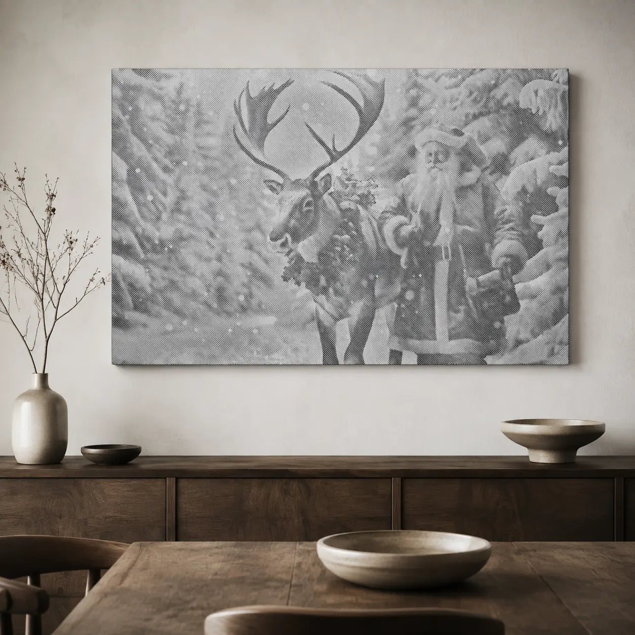 A large black and white canvas wall art print depicting Santa Claus and a reindeer in a snowy forest, displayed on a light beige wall above a dark wood console table with decorative bowls and a vase.