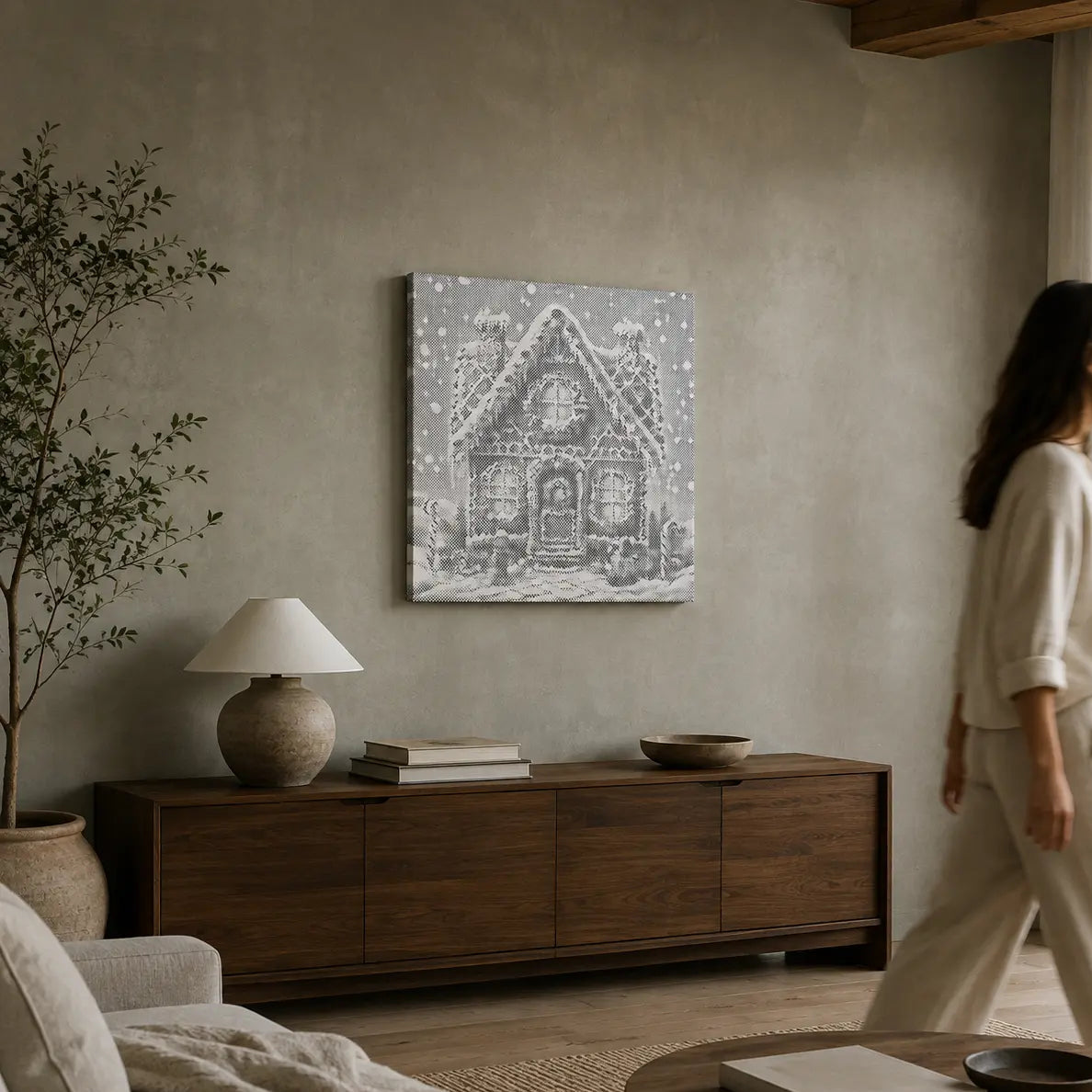 A woman in a cream lounge set walks past a wooden sideboard in a modern living room, with a black and white architectural art print hanging on the textured gray wall above.