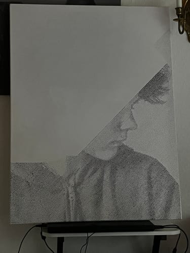 Customer's dot painting portrait in progress on a light pad
