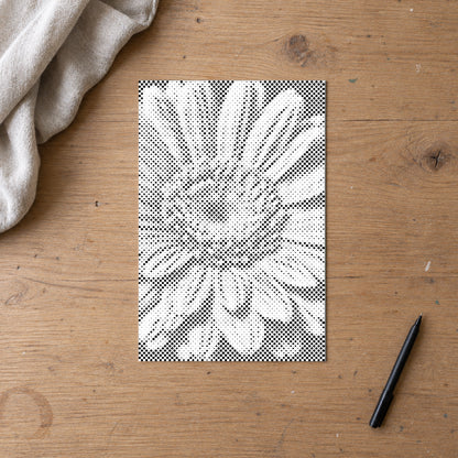 Prikmaleriet “Gerbera blomst”, set ovenfra på et arbejdsbord i blødt dagslys.
