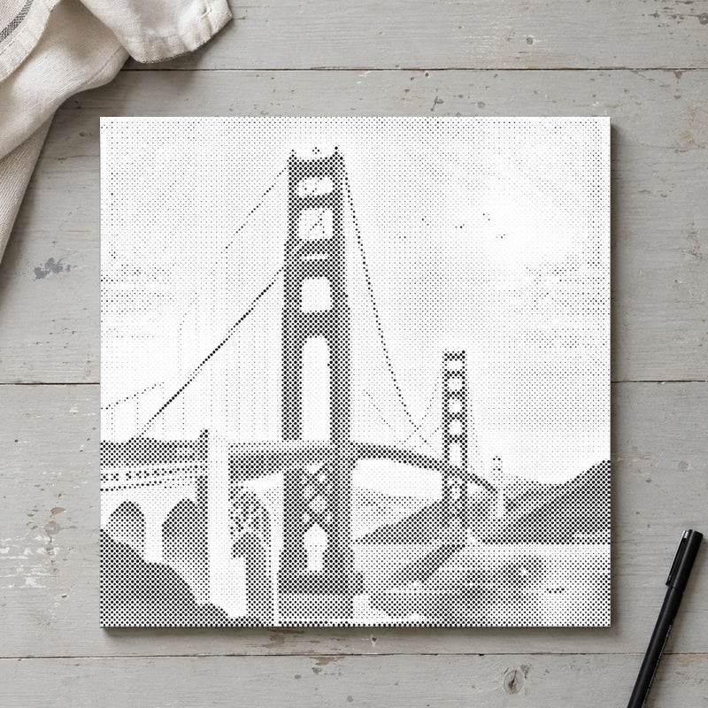 Prikmaleriet “Golden Gate Bridge”, set ovenfra på et arbejdsbord i blødt dagslys.
