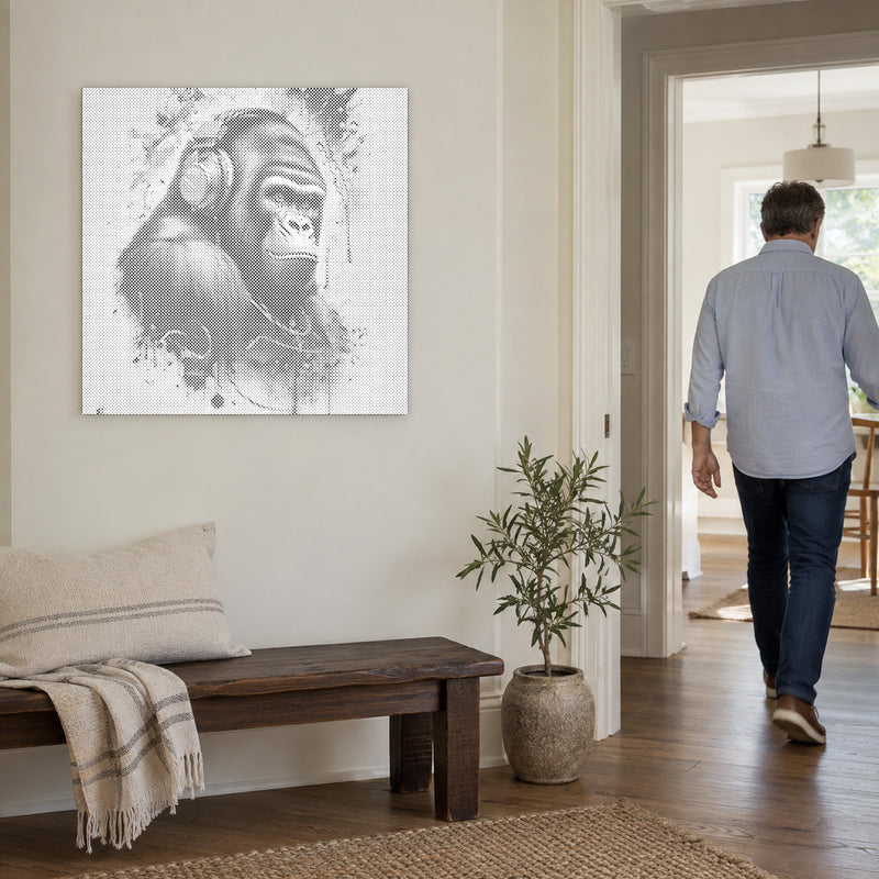 Prikmaleriet “Gorilla med høretelefoner”, på en lys væg med en person på vej gennem døren ved siden af.