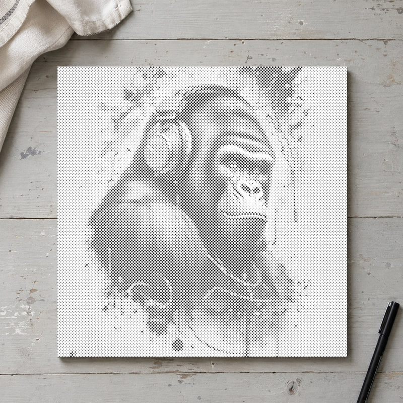 Prikmaleriet “Gorilla med høretelefoner”, set ovenfra på et arbejdsbord i blødt dagslys.