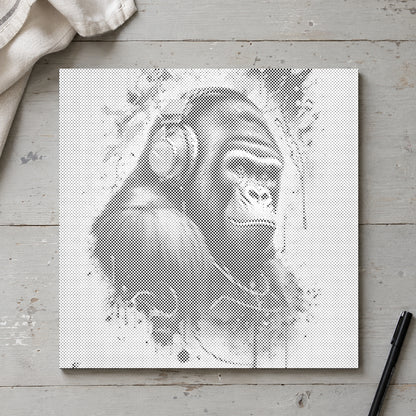 Prikmaleriet “Gorilla med høretelefoner”, set ovenfra på et arbejdsbord i blødt dagslys.