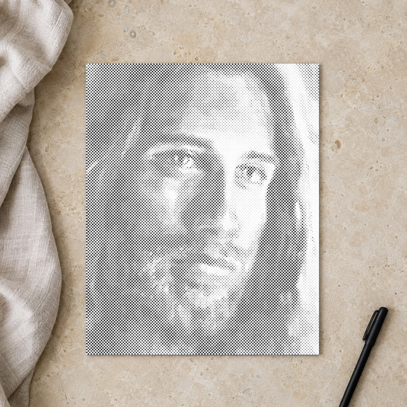 Prikmaleriet “Jesus Kristus”, set ovenfra på et arbejdsbord i blødt dagslys.