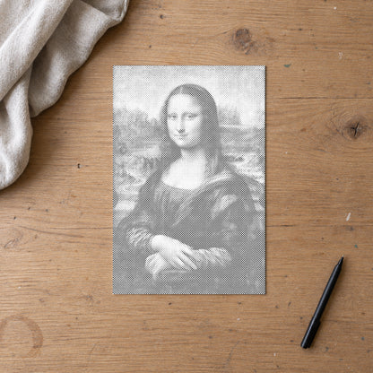 Prikmaleriet “Mona Lisa af Leonardo da Vinci”, set ovenfra på et arbejdsbord i blødt dagslys.