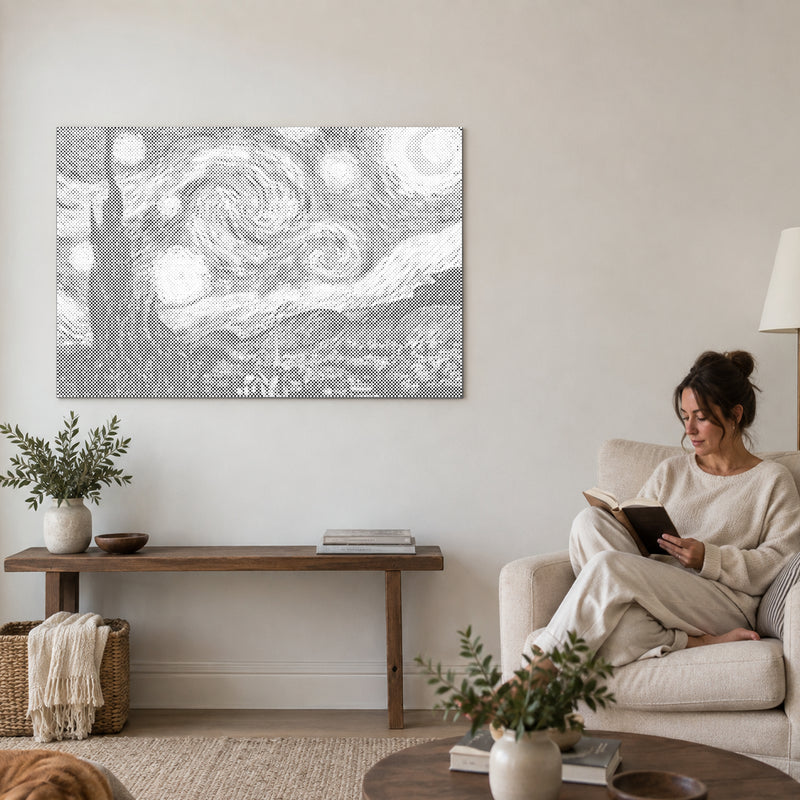 Prikmaleriet “Stjernenatten af Van Gogh”, på en væg i stuen med en person, der læser i en lænestol ved siden af.